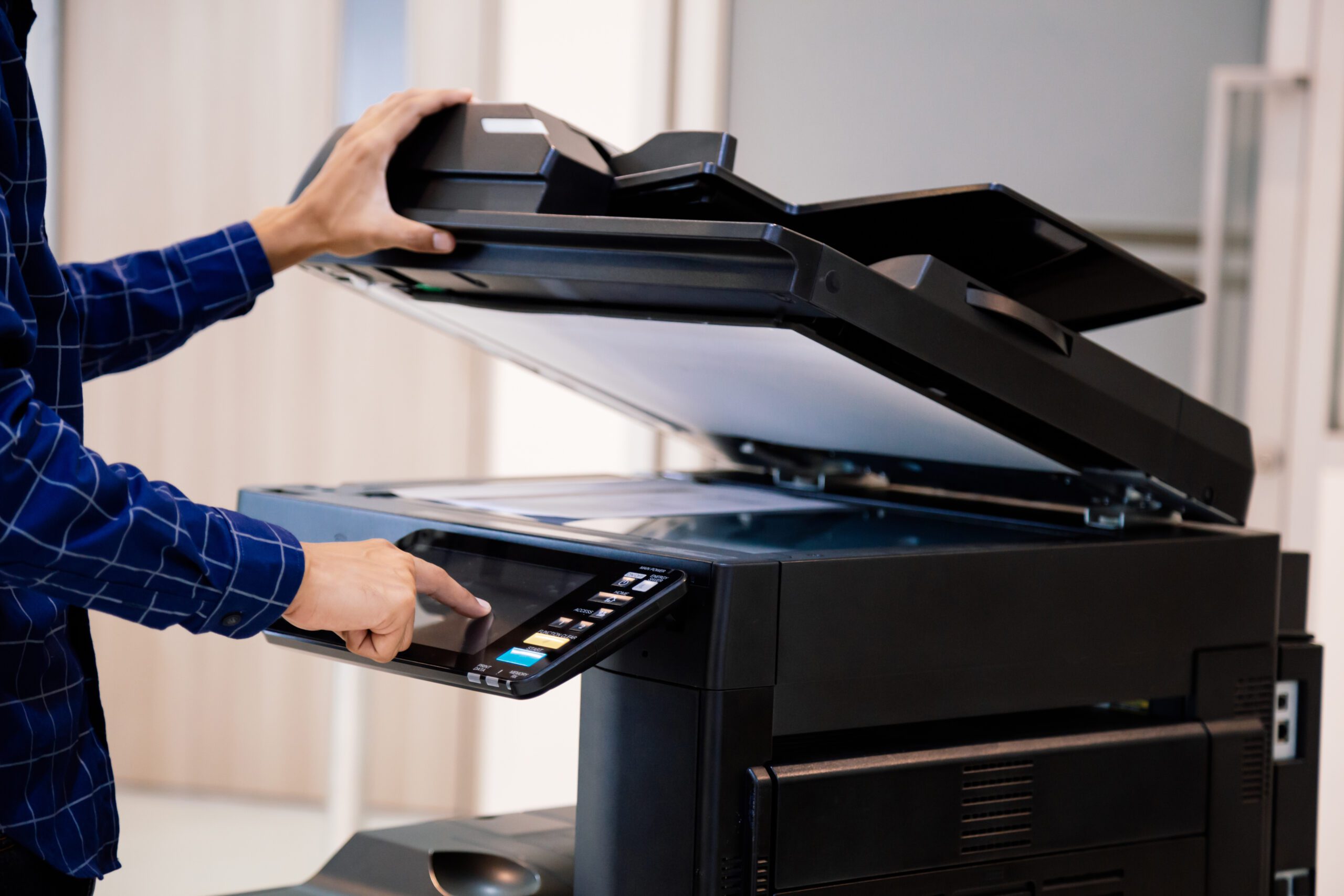 Businessmen press button on the panel for using photocopier or printer for printout and scanning document paper at office.