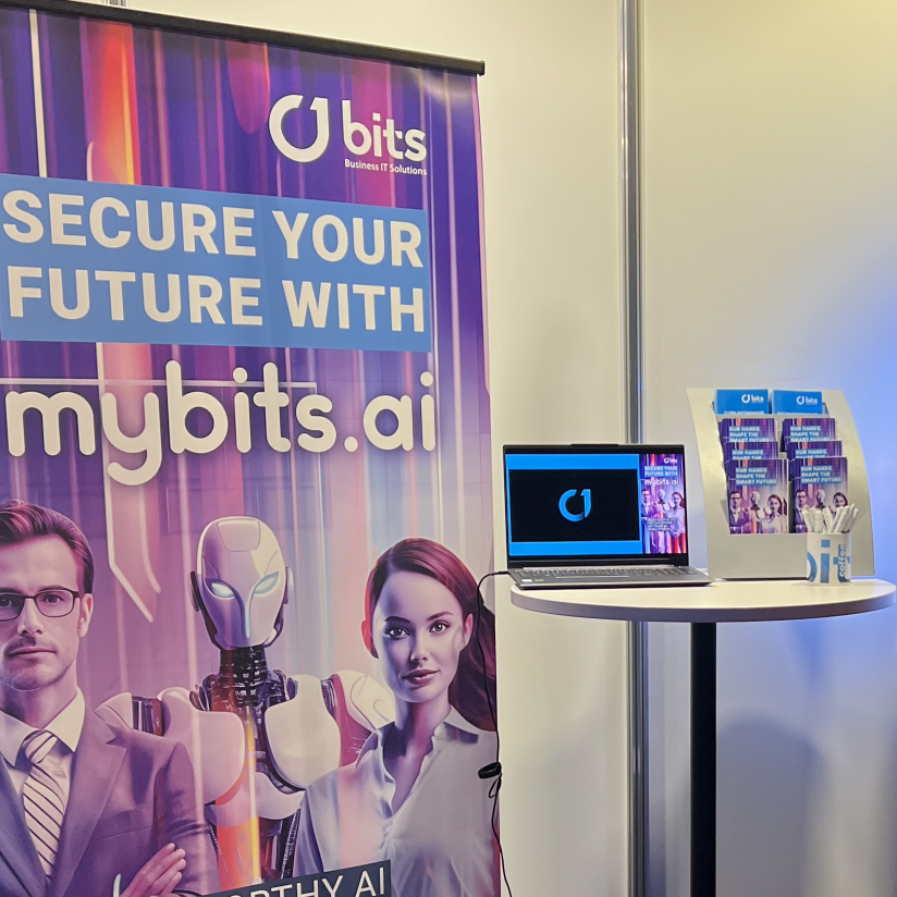 a laptop on a table next to a poster